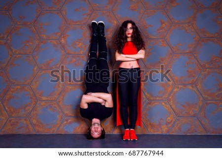 Dancers keep still. Guy standing on his head and girl standing on her legs  near the wall. 