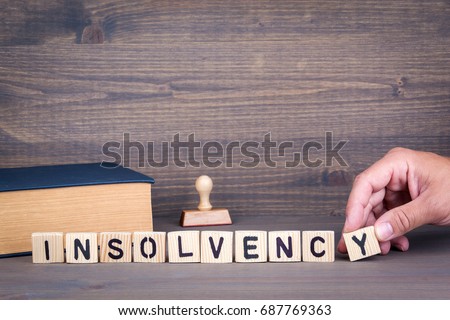 insolvency. Wooden letters on dark background Royalty-Free Stock Photo #687769363