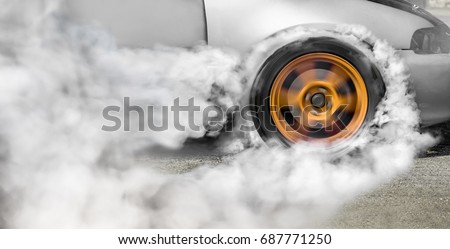 Drag racing car burns rubber off its tires in preparation for th Royalty-Free Stock Photo #687771250