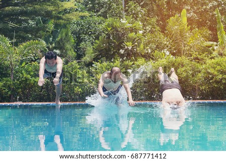 Friends having party  in a swimming pool. Young people are enjoying the holidays.
