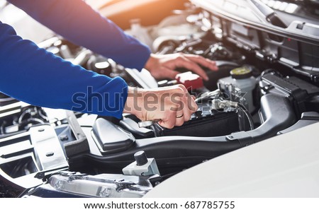 Hands of car mechanic with wrench in garage Royalty-Free Stock Photo #687785755