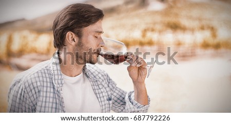 Man drinking red wine at vineyard