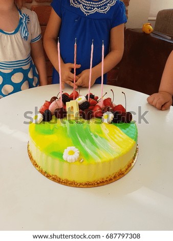 homemade birthday mousse cake with bright frosting with candles