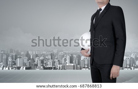 engineer or businessman in suit holding helmet with city visual background ready to design metropolis