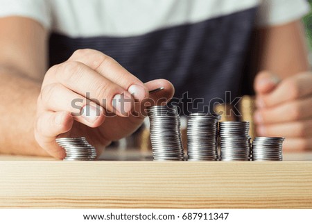 cropped view of person stacking coins on table, investment concept