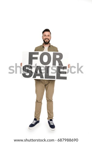 cheerful caucasian man holding for sale banner in hands isolated on white