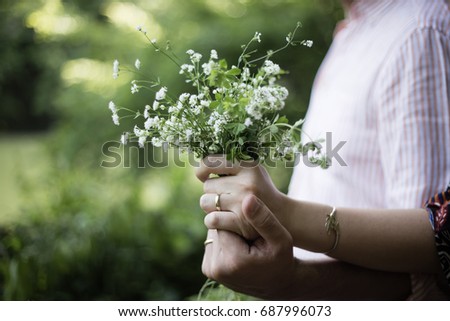 Romantic Couple Holging Hands with White Flowers