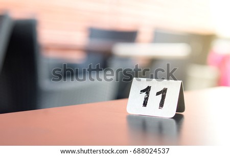 Number sign on restaurant table in outdoor terrace to show reservation. Customer waiting for service or food.