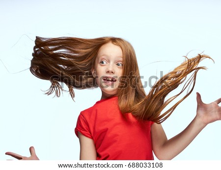 Girl with flying hair on a light background                               