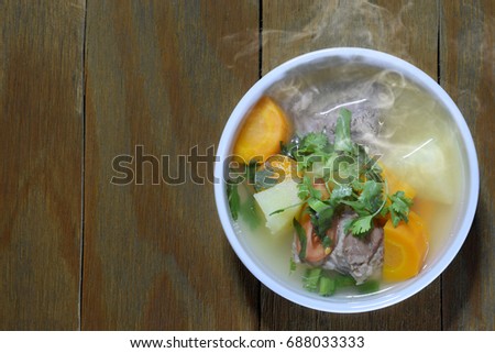 Beef soup in white bowl on brown wood. halal food