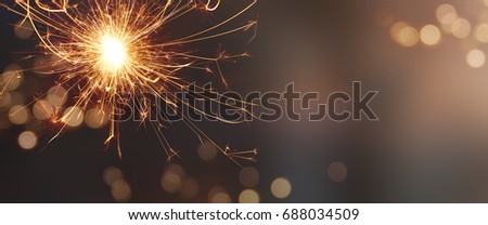 Festive background with sparkling wonder candle and tender golden bokeh for christmas