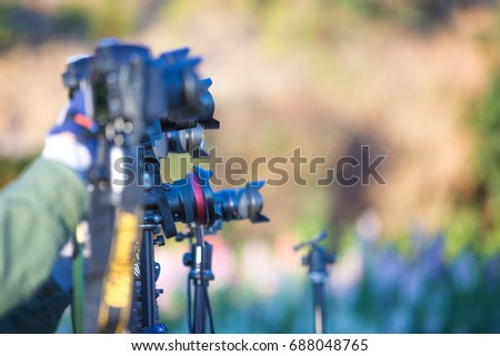 photographer setting camera on tripod, waiting for photography with group of camera 