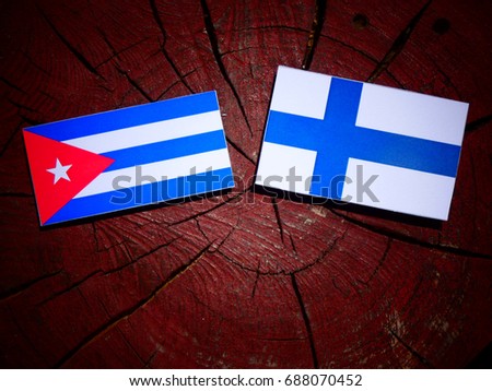 Cuban flag with Finnish flag on a tree stump isolated