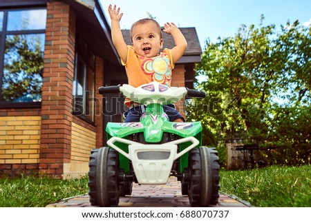 Baby girl driving a toy car Royalty-Free Stock Photo #688070737