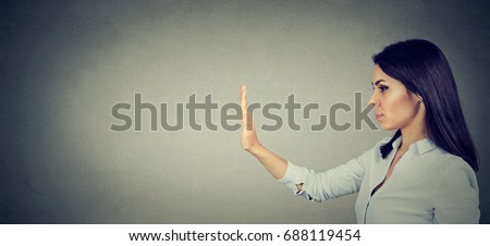 Side profile of young woman with stop hand gesture  Royalty-Free Stock Photo #688119454