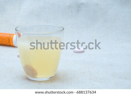 Effervescent tablet (vitamin) in a glass of water.