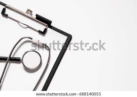 Stethoscope and clipboard with blank white sheet of paper and copy space