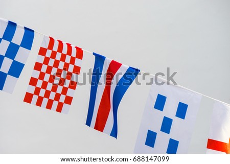 Flags on a flagpole fluttering in the wind on white background