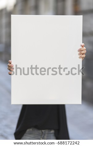Girl holds canvas background for graphic presentation