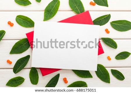 letter, red envelope, a sheet of paper, white wooden background with copy space