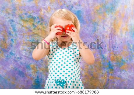 Child, little girl posing with red, juicy, ripe tomatoes. Vitamins of summer.