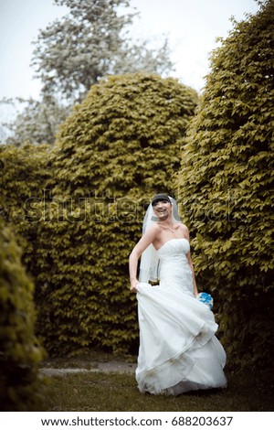 The bride with gathered hair one walks in the park