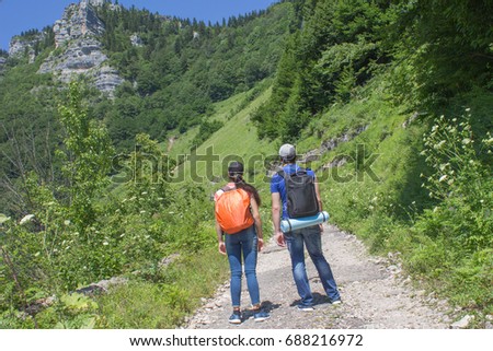 Travelers travel on the road in mountains go trekking together. Trekking together. Travel adventure and hiking activity, active and healthy lifestyle on summer vacation and weekend tour