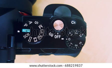 Close up image of camera buttons and dial. Auto mode. Wooden background. 