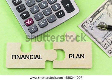 Money, calculator, notepad, puzzel and pen on green background. Business and commercial finance. FINANCIAL PLAN concept 