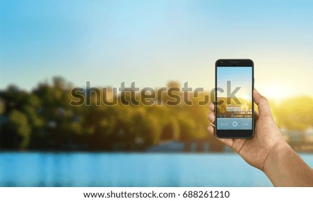 Tourist taking a picture of river using a smartphone, point of view shot