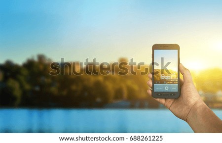 Tourist taking a picture of river using a smartphone, point of view shot
