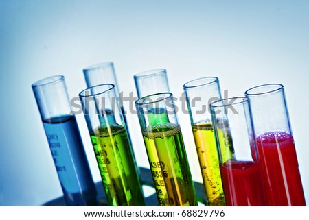 Multicoloured test tubes in the stand on blue background