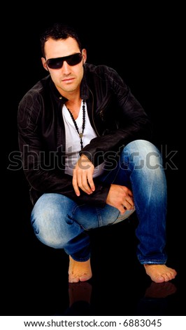 fashion man sitting on the floor over a black background