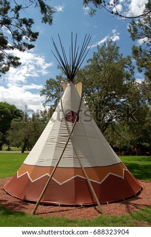Close up of Native American Teepee with beautiful blue sky and clouds in background
