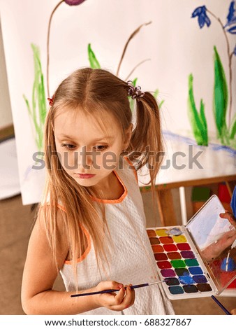 Children painting on easel. Girl with boy learn paint in class school. Child picture on background. Portrait of a student, top view.