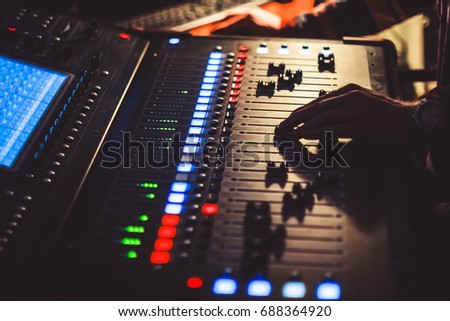 The hands of the sound engineer on the mixing console
