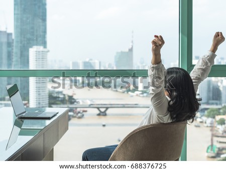Work done, life balance and success celebration concept with happy woman take it easy casually resting in luxury business hotel or at home office workplace with computer pc laptop on desk Royalty-Free Stock Photo #688376725