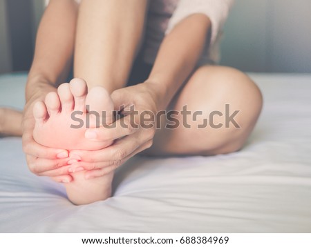 health care concept. woman massaging her painful foot, red hi-lighted on pain area Royalty-Free Stock Photo #688384969