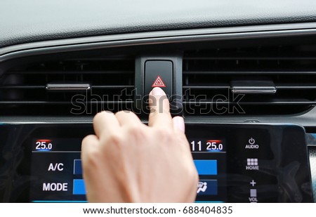 Finger hitting car emergency light button