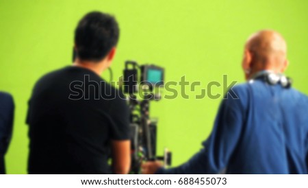 Blurred behind the scenes of video movie production in big studio with chromatic green screen background for online process technique 