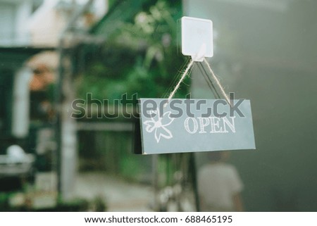 Open sign on glass door at flower shop