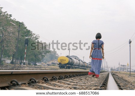 Beautiful woman in dress walking in railway. 