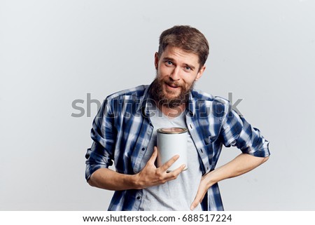 Man holding a jar of paint on a gray background repairing an apartment                               
