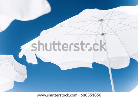 White summer umbrellas on blue sky background