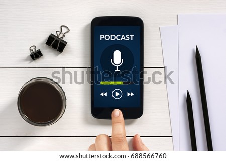 Podcast concept on smart phone screen with office objects on white wooden table. All screen content is designed by me. Flat lay