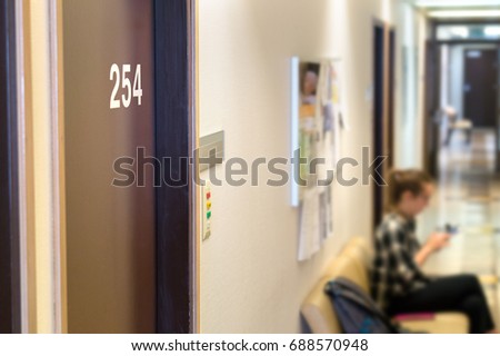 Doctor's waiting area or room in hospital. Principal's or curator's office in school. Patient or student waiting in the hallway. Door with a number.