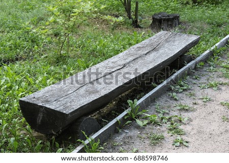 Bench from the trunk of tree in the park