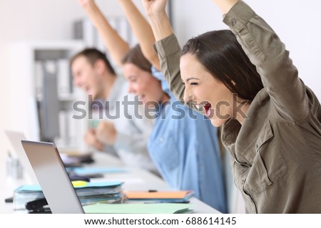 Three excited employees receiving good news on line in their laptops at office Royalty-Free Stock Photo #688614145