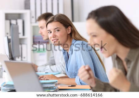 Portrait of a envious employee looking at a successful colleague at office Royalty-Free Stock Photo #688614166