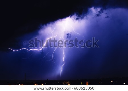 Photo of beautiful powerful lightning over big city, zipper and thunderstorm, abstract background, dark blue sky with bright electrical flash, bad weather concept